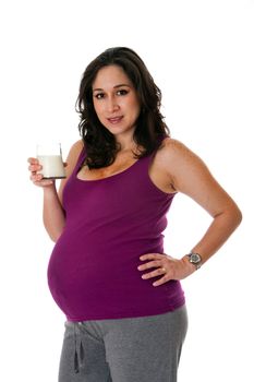 Beautiful Caucasian pregnant brunette woman holding glass of skim milk, isolated. Hispanic Latina female drinking milk as a great source of vitamine D and calcium to prevent osteoporosis and stimulate skeletal bone health.