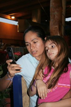 Mother and daughter typing on phone