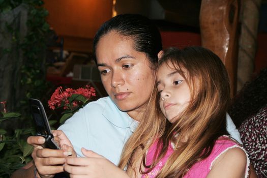 Mother and daughter typing on cell phone