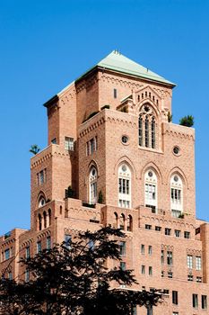 Old style 1920 nineteen twenties architecture brick apartment building with gothic arched windows against a blue summer sky. The Barbizon/63 condominiums, formerly known as The Melrose Hotel, in Manhattan, New York City. 