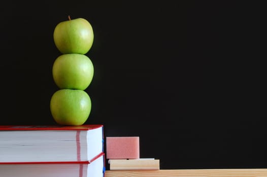 blank blackboard with apple and books and text space