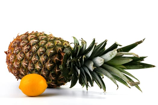 Tropical fruit on a white background: pineapple and a lemon.