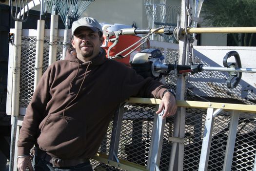 Landscaper standing next to his tool trailer