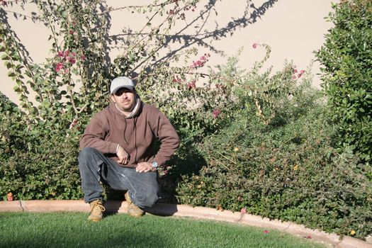 Man standing proudly next to well maintained garden