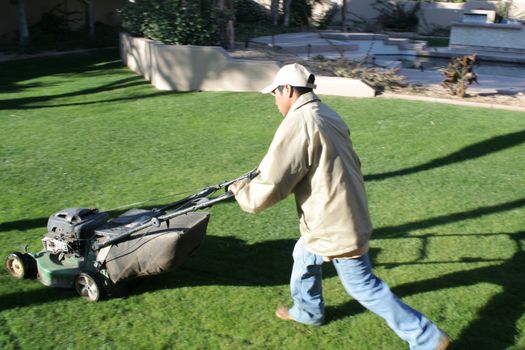 Man mowing lawn at upscal home