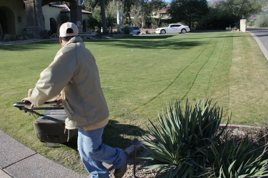 Man mowing yard of upscale home