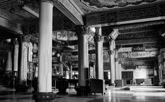 Inside temple structure of classic Chinese building with pillars and inscriptions.