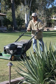 Man mowing yard of an upscale home