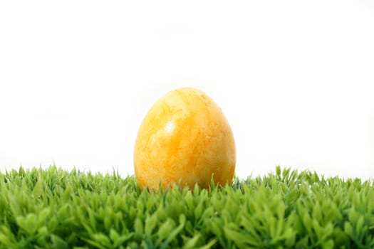 a yellow easter egg on grass