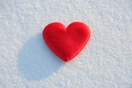 Red silk heart on the snow