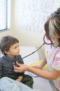 Young child getting a checkup from nures