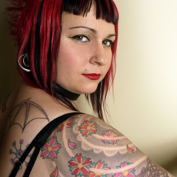 Portrait of a beautiful goth Queen covered in tattoos.
