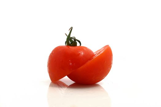 a tomato with a diagonal cut on a white background
