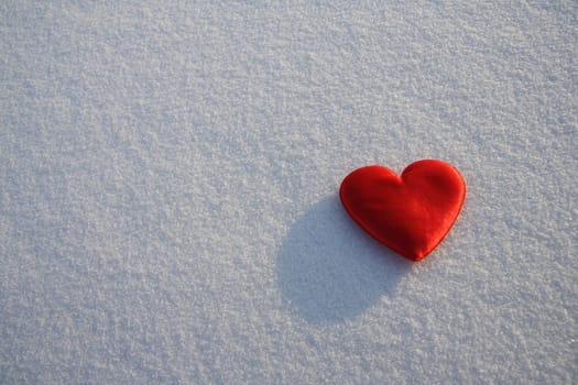 Red silk heart on the snow