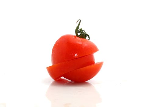 a tomato with two diagonal cuts on a white background
