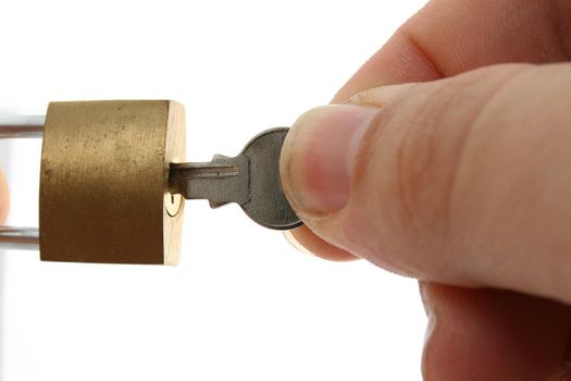 a hand opening a padlock with a key