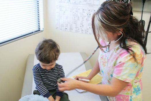 Young child getting a checkup from a nurse
