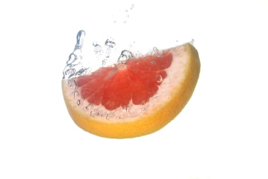 a grapefruit splashing in water