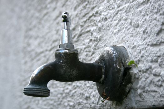 a water tap on a house wall
