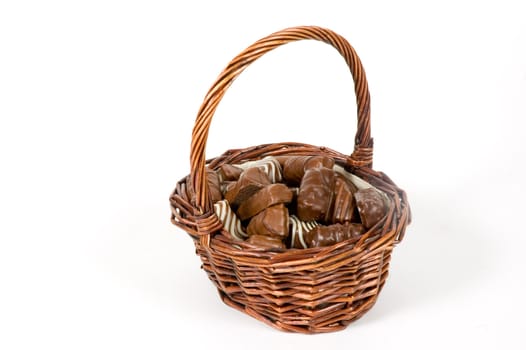 basket filled with delicious chocolates over white