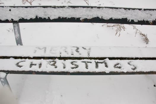 bench covered with snow and merry christmas