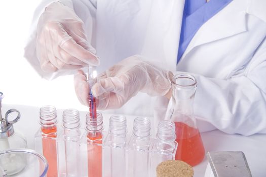 Young scientist in laboratory with test tubes and chemicals