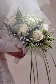 The bride holds a wedding bouquet