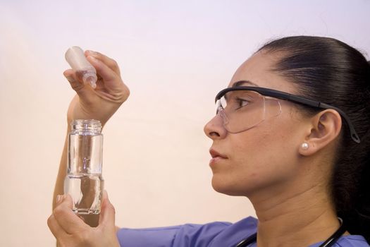 Pretty Hispanic nurse isolated on white testing chemicals