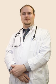 A young male doctor smiling isolated on white