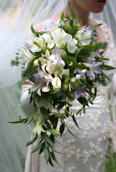 The bride holds a wedding bouquet