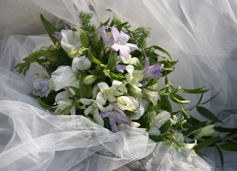 Wedding bouquet on a background of a veil