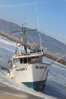 VENTURA, CA, USA - January 8, 2010 - The fishing boat SAI GON I ran aground after 4 people were rescued early morning. The rescue team tried to free the boat throughout the day January 8, 2010 in Ventura, CA