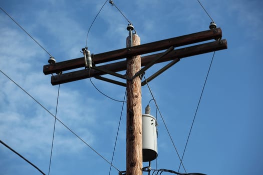 Power lines on a pole in the sky.