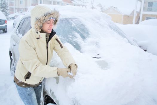 Woman removing snow from windshield