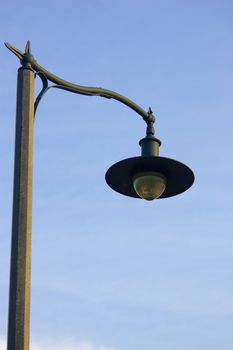 A public lamp post, isolated against a clear blue sky.