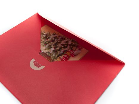 Closeup of a red christmas envelope with a card in it, isolated on white.