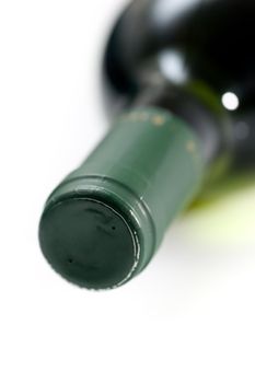Closeup of the neck and spout of a wine bottle, lying on its side.