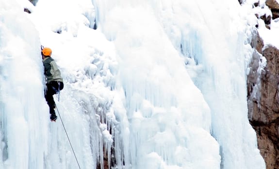 Man Ice Climbing Frozen Waterfall