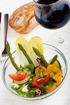 glass bowl of fresh salad with green asparagus