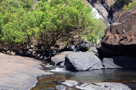 Small mountaineous river (creek) with waterfall in forest