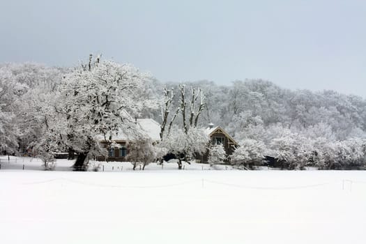 A small farm in a frosted winter landscape