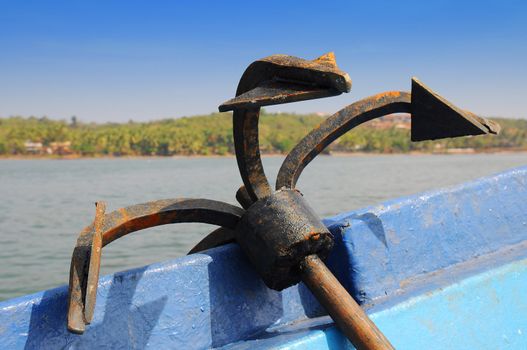 Rusty iron anchor on board a ship in open sea