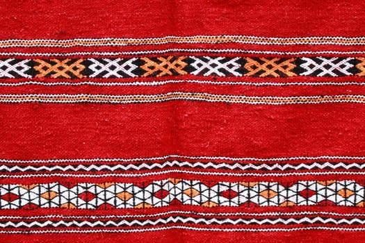 Red ethnographical handmade blanket with color pattern.