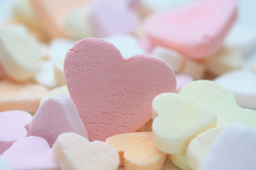 pink fruit candy heart on a pile of candy hearts