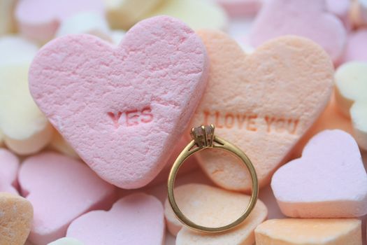 Solitaire diamond engagement ring on valentine candy heart with yes I love you text