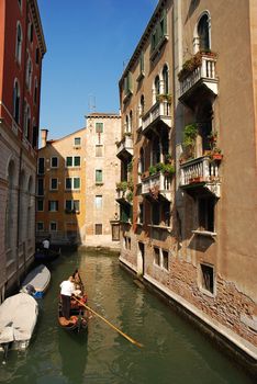 Gondola in venetian canal between buildings