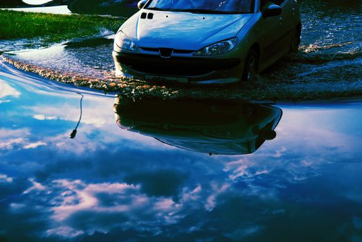 Car driving into the flood waters