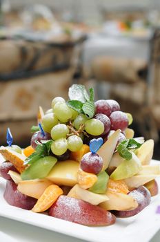 Fruit salad (grape, apple, pear, orange, mix) on a plate in fine restaurant