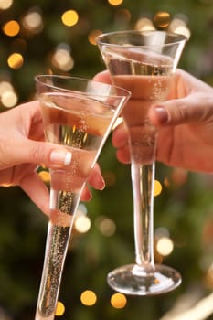 Man and Woman Toasting Champagne in Front of Decor and Lights.