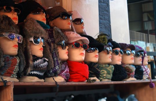 Row of mannequin heads with eyeglasses and fur-caps